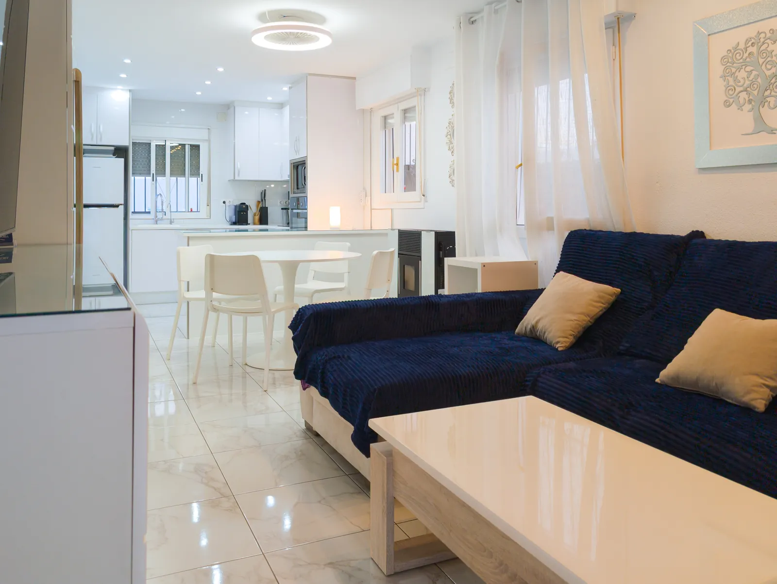 Living room with a large navy corner sofa and coffee table, open to the kitchen